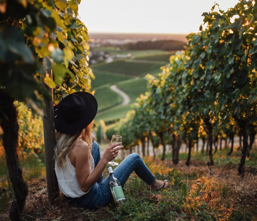 young-blonde-woman-relaxing-vineyards-summer-season-with-bottle-wine